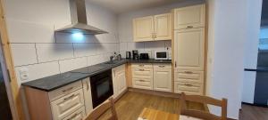 a kitchen with white cabinets and a stove top oven at Gästehaus Bergwald in Kurort Gohrisch