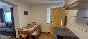 a kitchen and dining room with a table and a refrigerator at Gästehaus Bergwald in Kurort Gohrisch
