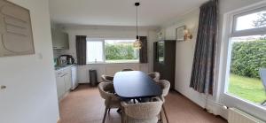 a kitchen with a table and chairs in a room at Dunopark Bungalow in Oostkapelle