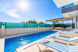 a swimming pool with two lounge chairs next to a house at Villa Horizon in Ortaca