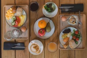 a wooden table topped with plates of breakfast food at The Usual Rotterdam in Rotterdam