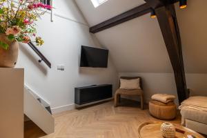 a living room with a flat screen tv and a couch at De Kroonkamer in Loenen aan de Vecht