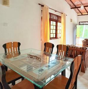 a dining room with a glass table and chairs at Laa Villa Kandy in Kandy