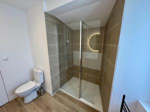 a bathroom with a toilet and a glass shower at la capeline in Chablis