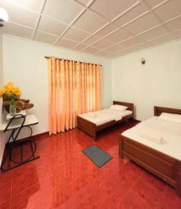 a room with two beds and a red floor at Laa Villa Kandy in Kandy