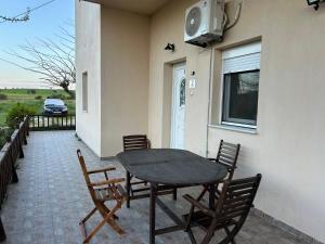 a table and chairs on a patio with a window at Akrotiri Studios in Samothraki
