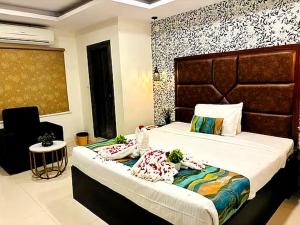 a bedroom with a bed and a chair at Hotel MEGA International Airport Zone in Hyderabad