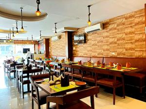 a restaurant with tables and chairs and a brick wall at Hotel MEGA International Airport Zone in Hyderabad