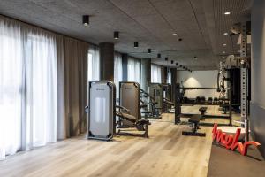 a gym with treadmills and machines in a room at ARCOTEL Tabakfabrik Linz in Linz +87 photos