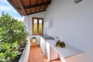 an outdoor kitchen with white countertops and plants at Don Giorgio Studios in Ischia Town
