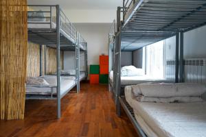 a room with three bunk beds in a room with wooden floors at San Sebastian Surf and Party Hostel in Aia