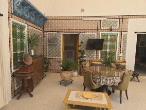 a living room with a table and a tv at Dar lel khedija in Mahdia