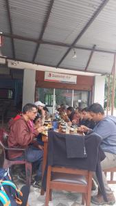a group of people sitting at a table eating food at B N Hotel & Restaurant in Rāmechhāp