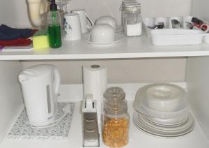 a white shelf with dishes and other items on it at Rosy Palm Sunrise in Upington