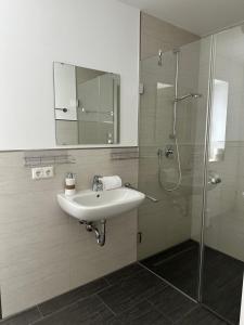 a bathroom with a sink and a shower with a mirror at Apartment Seeglück am Schliersee - modern, zentral, perfekt für Familien in Schliersee +10 photos