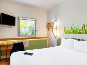 a hotel room with a large bed and a desk at ibis budget Derby in Derby