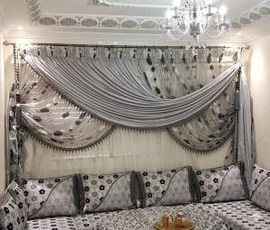 a living room with a couch and a curtain at Jawharat Tetouan in Souani