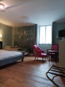 a bedroom with a bed and a painting on the wall at Maison Lasmarenx chambres d'hôtes in Jurançon