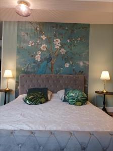 a bedroom with a large bed with a painting on the wall at Maison Lasmarenx chambres d'hôtes in Jurançon +80 photos