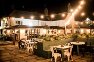 an outdoor restaurant with tables and chairs at night at Fisherman's Haunt Hotel in Christchurch