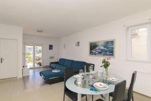 a living room with a table and a blue couch at Apartments Irena in Tkon
