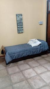 a bed in a room with a sign on the wall at Lo de Lety in Baradero