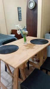 a wooden table with two plates and a vase of flowers at Lo de Lety in Baradero +6 photos