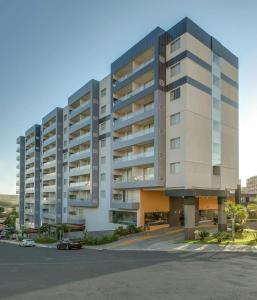 a large building with a parking lot in front of it at Flat Veredas Rio Quente-GO in Rio Quente