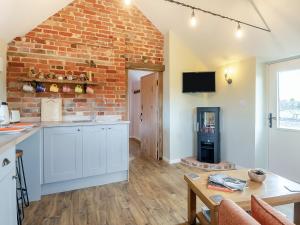 a kitchen and living room with a brick wall at Alberts Dairy in Diss