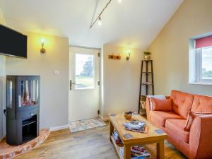 a living room with a couch and a fireplace at Alberts Dairy in Diss