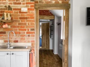 a kitchen with a brick wall and a sink at Alberts Dairy in Diss