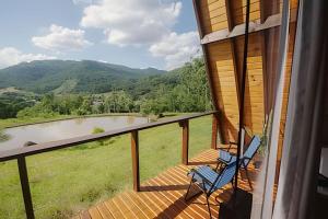 a balcony with a chair and a view of a river at Alabama Cabin - Serra Gaúcha in Picada Cafe
