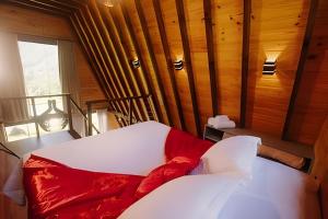 a bedroom with a white bed with a red pillow at Alabama Cabin - Serra Gaúcha in Picada Cafe