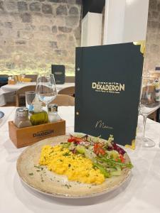 a plate of food on a table with a book at Step to Kotor Bay Old Town in Kotor