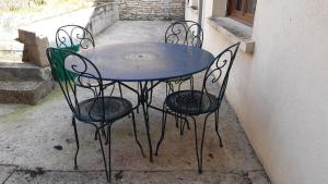 a blue table with four chairs sitting next to a building at Dépendance du Duesmois in Fontaines-en-Duesmois