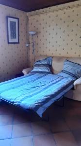 a bedroom with a bed with blue sheets and a lamp at Dépendance du Duesmois in Fontaines-en-Duesmois