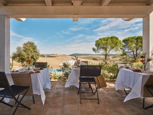 a patio with tables and chairs with a view of a field at Villa Eos in Chiusure