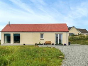 a house with a red roof on a gravel road at Taigh Mullach Dearg in Portree
