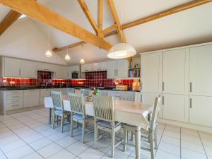 a kitchen with white cabinets and a wooden table and chairs at The Cart House in Helmsley