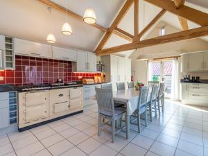 a kitchen with white cabinets and a table and chairs at The Cart House in Helmsley +24 photos