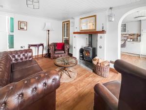 a living room with leather furniture and a fireplace at Croftbank in Lochranza