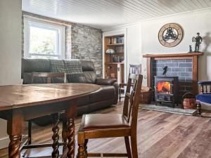 a living room with a table and a fireplace at Croftbank in Lochranza +22 photos