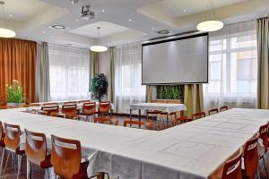 a large conference room with a large screen at Hotel Olympionik in Mělník