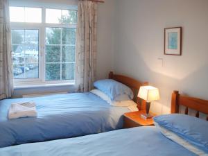 a bedroom with two beds and a window at The Fells in Keswick