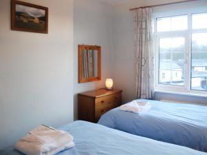 a bedroom with two twin beds and a window at The Fells in Keswick