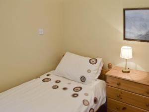 a bedroom with a bed with a pillow and a nightstand at The Fells in Keswick