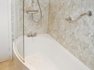 a shower with a white tub in a bathroom at The Fells in Keswick
