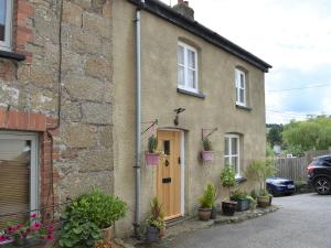 a brick house with a door and potted plants at Scenery Cottage in Bridford