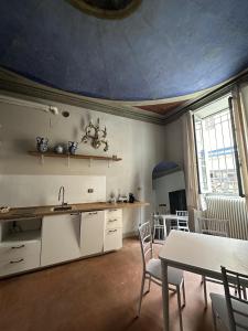 a kitchen with a table and a dining room at Le Suite Di Faenza in Faenza