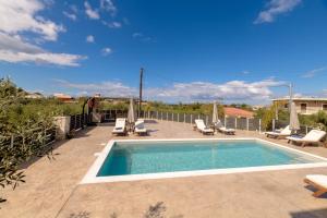 a swimming pool with chaise lounge chairs and a swimming pool at Athenia Apartments in Vasilikos